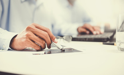 Businessmen are busy their work on paper and on the computer screen his.