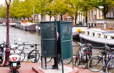 Fototapeta premium Man urinating in Amsterdam in a public urinal