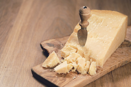 Pieces Of Hard Parmesan Cheese On Olive Board From Above