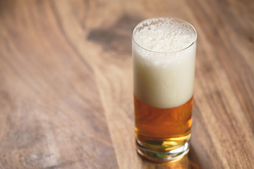 lager beer in glass on wood board