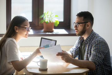 Two businesspeople discussing details of a contract. Concerned Ð¼an asking financial advisor about conditions of mortgage. Getting a new home  loan concept.