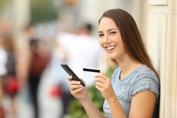 On line shopper looking at camera holding card