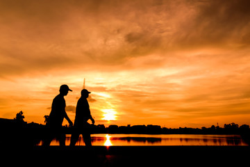 Fototapeta na wymiar Silhouette of people jogging for exercise in park at sunset. May use for abstract background.