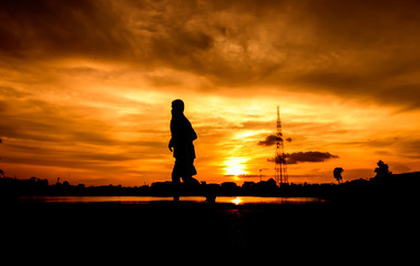 Silhouette of people  jogging for exercise in park at sunset. May use for abstract background.