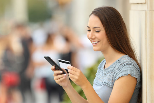 Girl paying on line with a credit card and phone