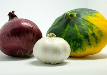 spotted squash on a white background, onion and garlic
