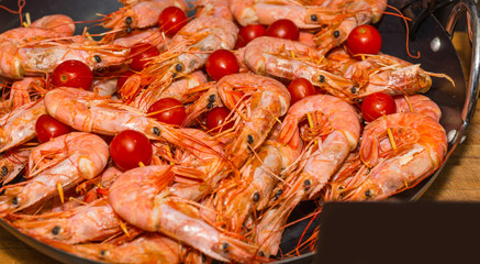 Appetizing cooked shrimps with tomatoes at food festival