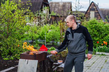 man cooks barbecue