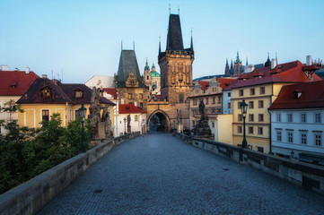 Fototapeta na wymiar Charles Bridge in Prague in the early morning. View of Malostranska Tower and Judithin Tower. In the background on the mountain you can see Prague Castle.