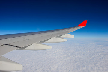 Wing of airplane in the sky red winglet blue sky