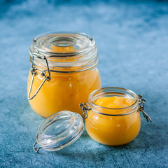 Lemon Curd in Jars over Blue Background