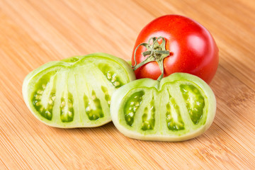 Fresh red and green tomatoes on a wood background