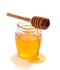 jar of honey and dipper on white background