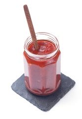 tomato sauce in glass jar on white