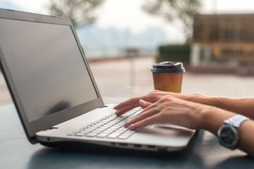 Close up shot of female hands typing on a laptop keyboard