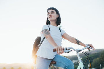 Happy beautiful hipster millennial woman or teenager with cool arm tattoos, is tourist in summer of...
