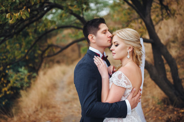 The couple in love are hugging each other in the autumn forest. Wedding concept.
