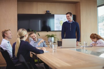 Happy business colleagues discussing during meeting