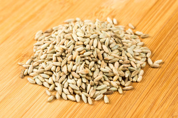 Rye berry grains on a wood background