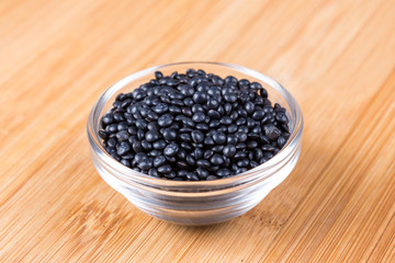 Black beluga lentils on a wood background