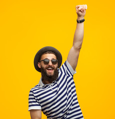 Naklejka premium Victorious hipster posing on orange
