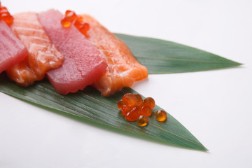 Sashimi set on bamboo leaf isolated at white