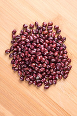Red adzuki beans on a wood background