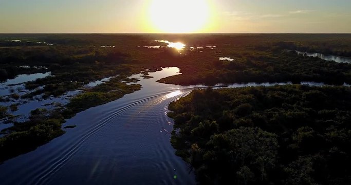Sunset in the Pantanal Biome.Boat goes away. Vegetation of forest. Beautiful landscape of Mato Grosso do Sul state, Central-Western Brazil. Aerial image.