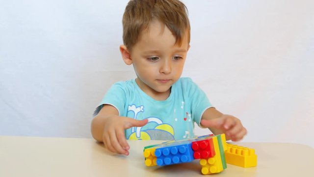 The child collects the tower from the colored blocks.