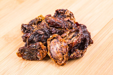 Organic sun dried tomatoes on a wood background