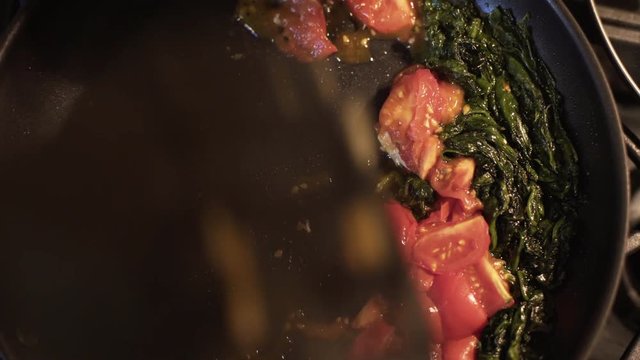 overhead shot sauteing spinach and tomatoes 4k