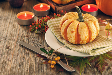 Autumn table setting with pumpkings and candles, fall home decoration for festive dinner