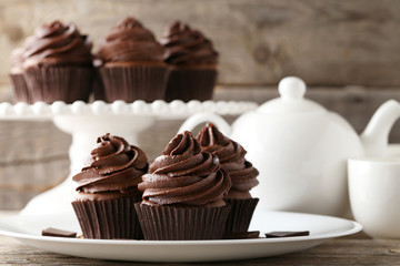 Chocolate cupcakes in plate on grey wooden table