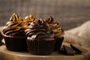 Tasty chocolate cupcakes on grey wooden table