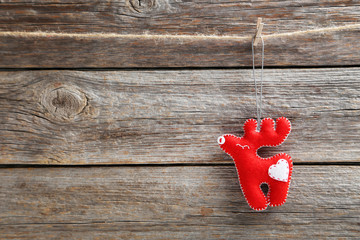 Christmas decoration hanging on rope on wooden background