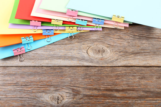 Colored papers with clamps on wooden table