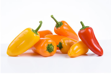 Vibrant small peppers on white background