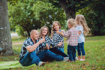 Fototapeta premium Young family with cheerful children in the park