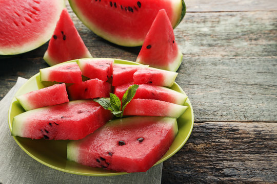 Slices of watermelons in plate on wooden table