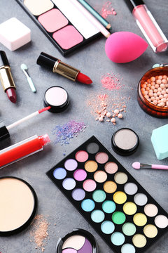 Different makeup cosmetics on grey wooden table