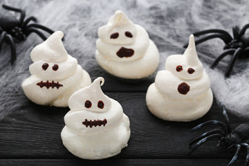 Halloween meringue with spiders on black wooden table
