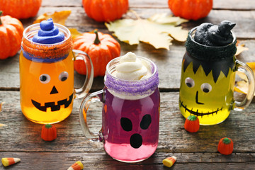 Halloween jelly in glass jars with candies on wooden table