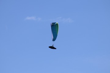 Gleitschirmflieger (Paraglider) vor blauem Himmel