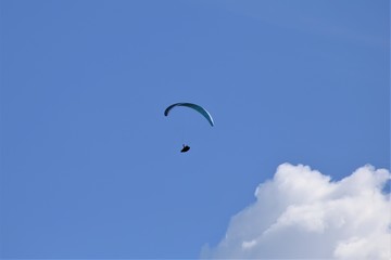 Gleitschirmflieger (Paraglider) vor blauem Himmel