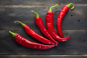 Red chilli peppers on black wooden board