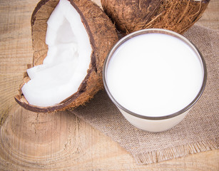 Coconut with coconut milk on wooden background.