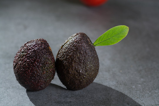 Ripe avocado close up on gray concrete background, healthy food concept, copy space