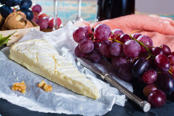 Famous French fresh soft cheese - brie, delicious dessert with nuts and dried fruits