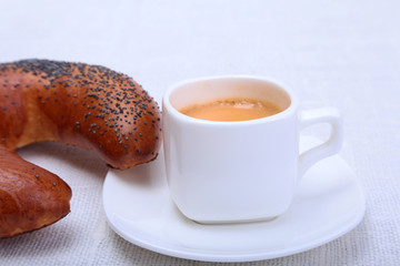 Classic espresso in white cup with cake on white background.
