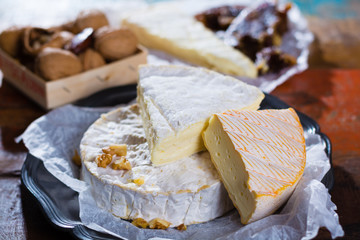 French soft cheeses - camembert, marcaire, munster, brie - delicious dessert with nuts and dried fruits